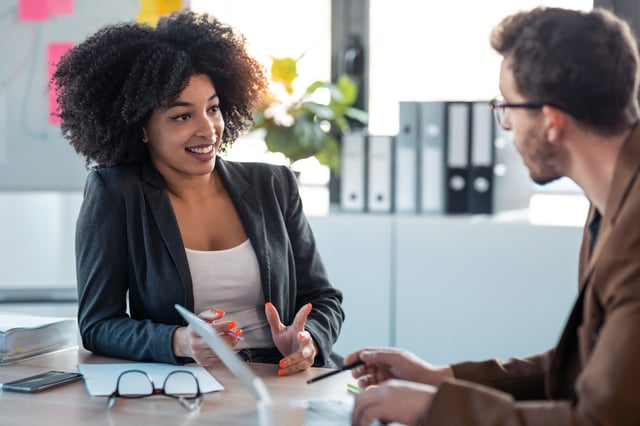 Two people talking about how and when to be assertive at work