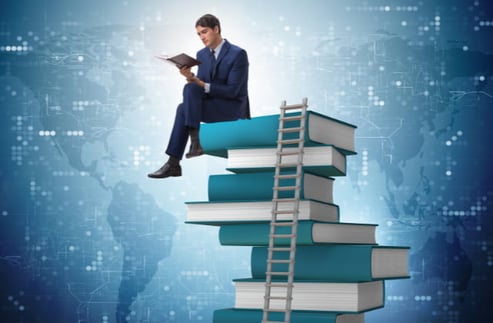 Person sat on books learning how to develop a training program for employees