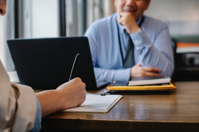 Two employees learning how to write a policies and procedures