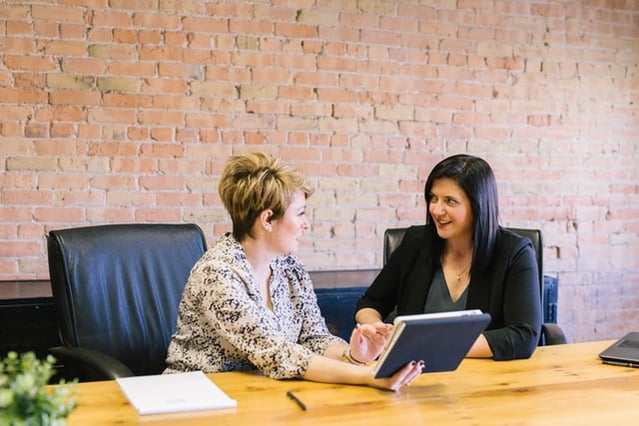 Two women discussing ways to monitor staff and increase motivation