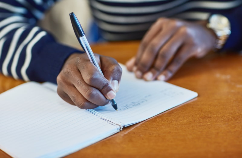 Person using note-taking methods to improve their skills for the workplace