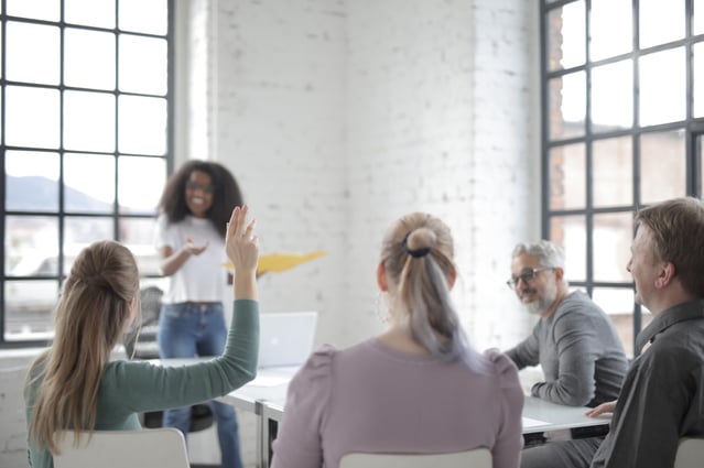 People sat round a table discussing face-to-face training courses for the public sector