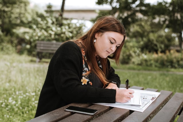 Woman writing down the top public sector writing courses in 2021 