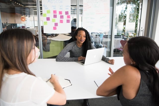 Three public sector employees discussing different methods of giving feedback