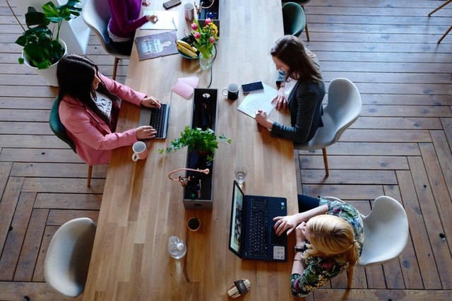 Three women working and researching how to prevent unconscious bias in the workplace