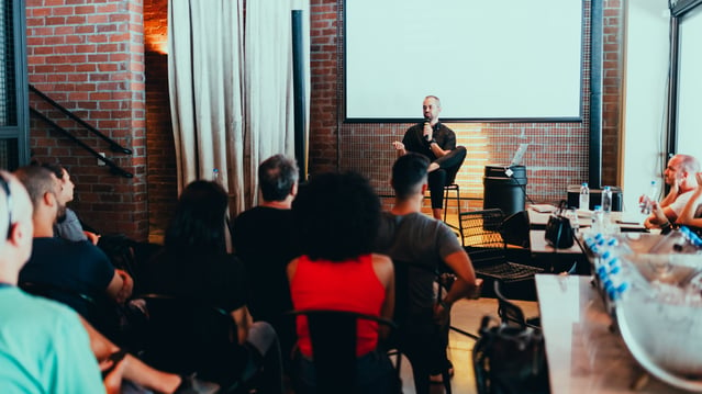 Person stood at the front of the room teaching people how to improve your public speaking skills