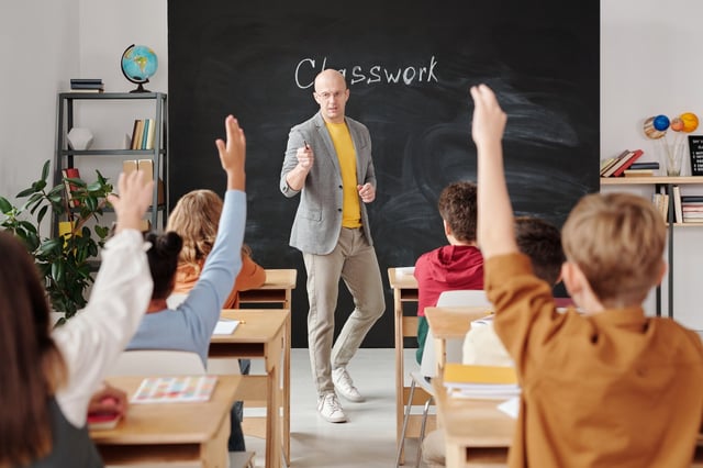 Teacher at the front of the class removing disruptive behaviour 