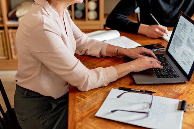 Person using laptop to learn how to improve team leadership skills