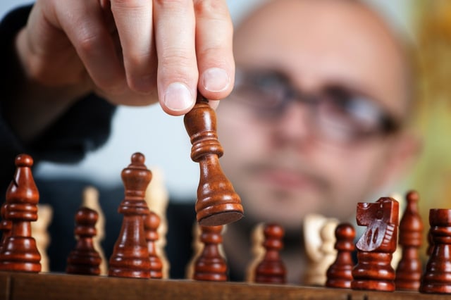 Person playing chess to learn how to be an effective strategic thinker