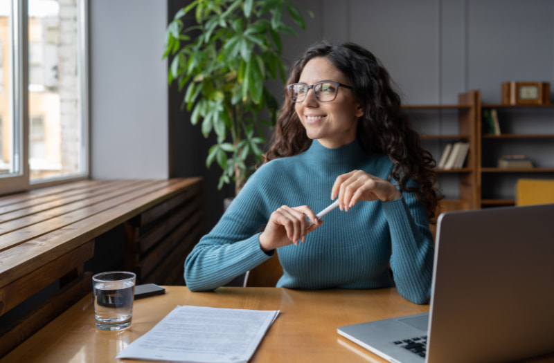 Person sitting at a desk using a laptop to measure employee wellbeing