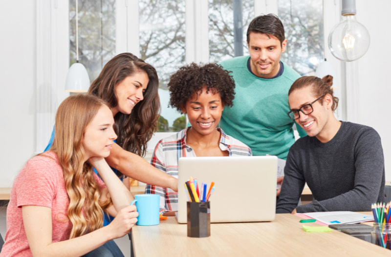 Group of people using a laptop in the workplace