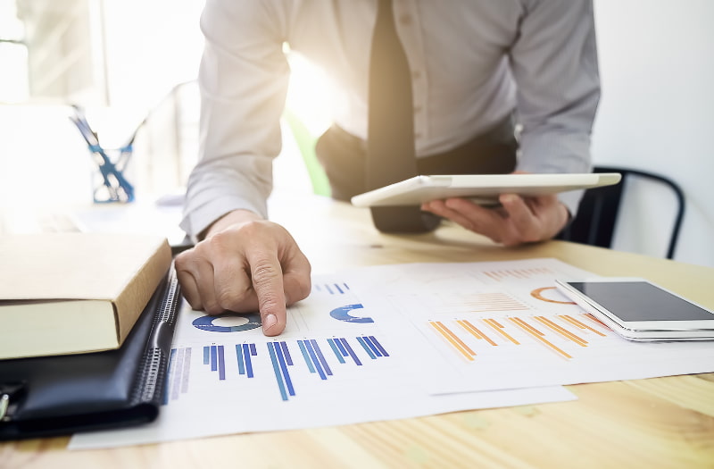 Person using tablet and graphs to measure the ROI of training